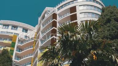 现代多层酒店和蓝天棕榈树